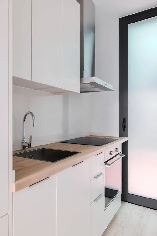 small kitchen with white cabinets and wooden countertop